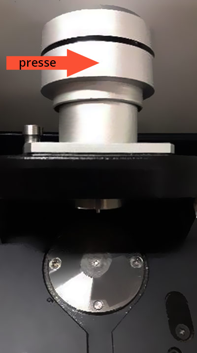 Photo présentant la presse, montée sur un couvercle métalique au dessus du cristal, permettant de superposer la presse sur le cristal