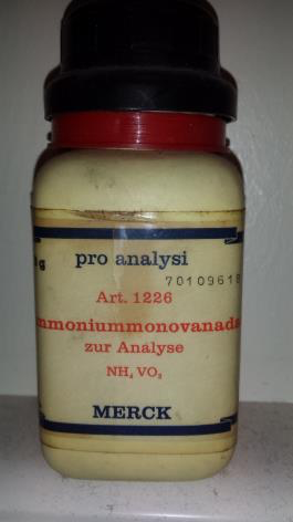 Photo d'un contenant en plastique. L'étiquette est écrite en allemand, et indique que le contenu est du sel de vanadate d’ammonium.