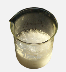 Photo of a beaker containing citric acid crystals