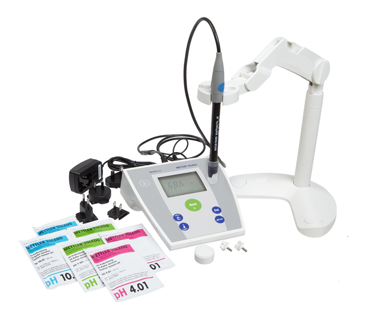 Photo of a pH meter. On the right is a stand, to hold the electrode. In the center is the electrode connected to the main unit, on which are buttons and a display screen. On the left are 6 standard solutions.