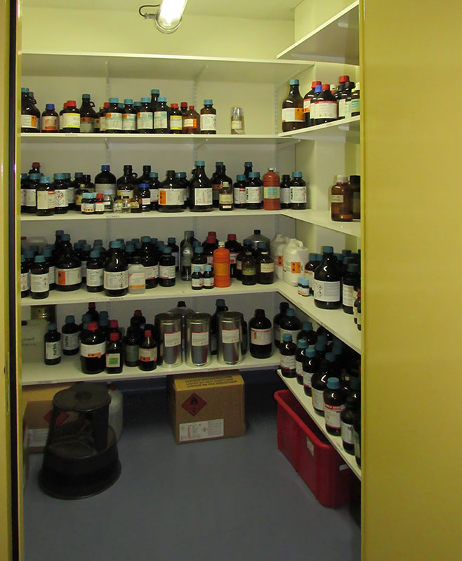Photo d'un pièce de stockage dans laquelle se trouve des étagère sur lesquelles reposent des flacons et bouteilles